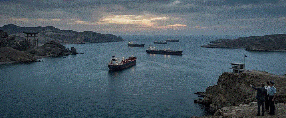 "مشهد جوي لمضيق هرمز يظهر ناقلات نفط تعبر الممر المائي بين جبال شاهقة في وقت الغروب، مع وجود شخصيات رسمية تراقب الممر من المرتفعات."