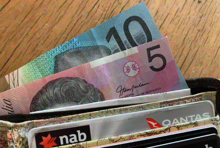 نقود أسترالية من فئة 5 و10 دولارات داخل محفظة بجانب بطاقات بنكية