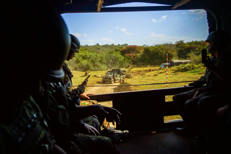 جنود داخل مركبة عسكرية مدرعة يراقبون تحرك آليات عسكرية في ميدان مفتوح خلال مهمة ميدانية