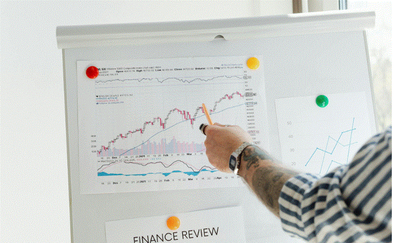 رجل يشير إلى مخطط بياني يعرض بيانات اقتصادية واتجاهات سوق العمل على لوحة عرض