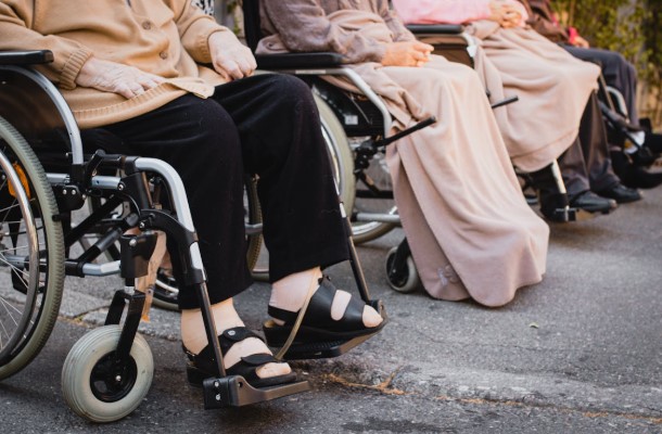 أشخاص من ذوي الإعاقة يجلسون على كراسي متحركة في مكان عام، في مشهد يعكس أهمية الدعم الاجتماعي والمشاركة المجتمعية.