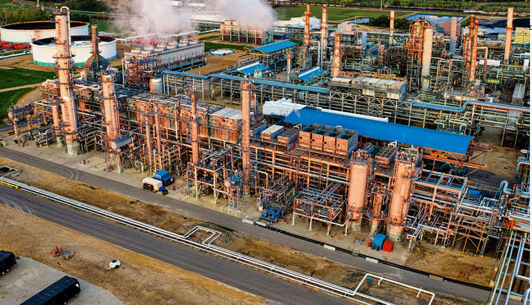 مصفاة نفط صناعية كبيرة مع خزانات وأنابيب ضخمة تعمل في معالجة الوقود وإنتاج المشتقات النفطية