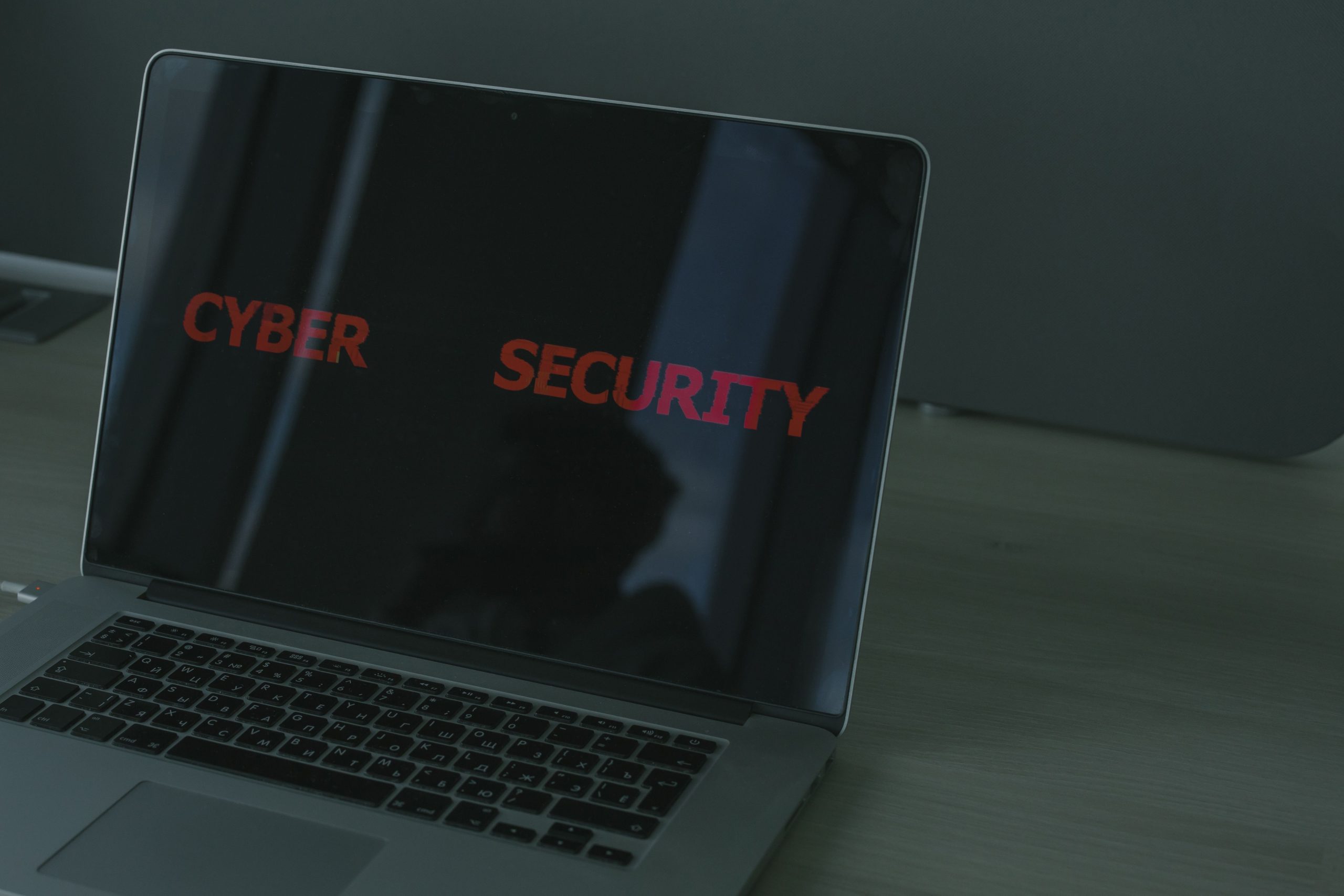شاشة حاسوب محمول تعرض عبارة "Cyber Security" في إشارة إلى الأمن السيبراني والتعاون الدولي لمواجهة التهديدات الرقمية والهجينة.