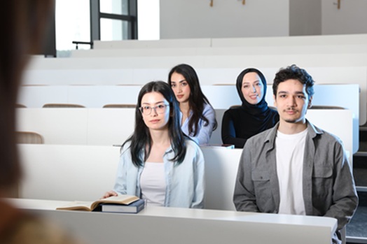 طلاب دوليون يجلسون داخل قاعة محاضرات جامعية في أستراليا وسط نقاش حول تغييرات تأشيرات الطلاب والخريجين.